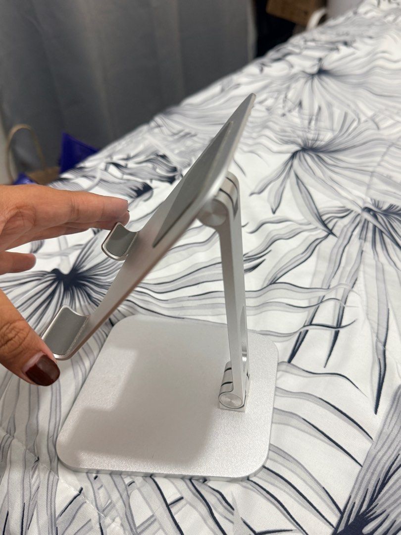 Adjustable Aluminum Tablet Stand (Category: Mounts & Holders) located in Cainta. Submitted by zairaelli (Listing ID 1415011006, Image 3). Description: - Silver aluminum phone stand - Foldable design - Adjustable viewing angles - Rectangular base - Compatible with various phone/ tablet sizes - Easy to store.