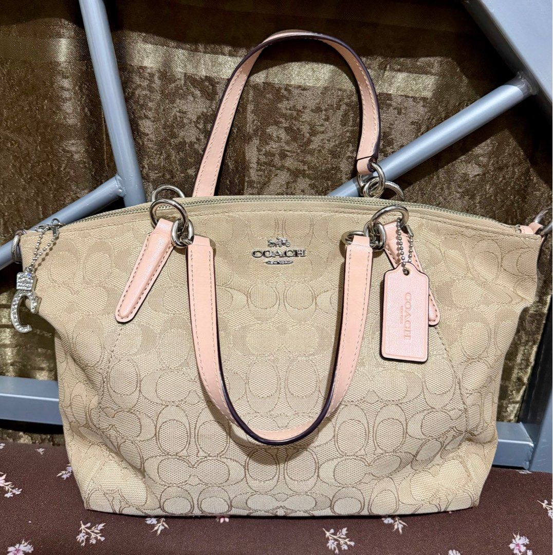Coach Small Kelsey Satchel Bag (Category: Luxury Bags & Wallets) located in General Trias. Submitted by senorita_0528 (Listing ID 1414894621, Image 1). Description: Preloved Coach Small Kelsey Satchel Bag Signature pattern Color: Beige with pink accents Features: Zip closure, double handles, detachable shoulder strap Includes Coach hangtag Interior: Pink lining, small pocket Issue: Creed is damaged (see photos) ₱2,000.