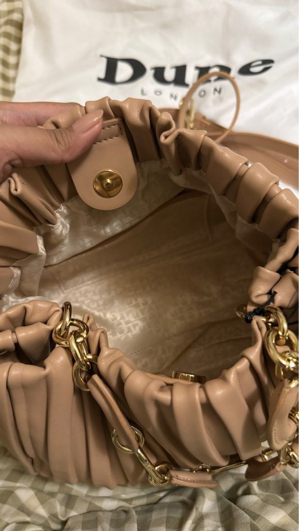 Dune London Pleated Handbag with Chain Strap (Category: Luxury Bags & Wallets) located in Makati City. Submitted by mrypauline (Listing ID 1414956383, Image 2). Description: - Dune London handbag - Pleated design - Light beige/nude color - Chain strap - Magnetic closure - Spacious interior - Unused condition - Includes dust bag and original tags - Adds sophistication to any outfit Rfs: ayaw nung reregaluhan :( .