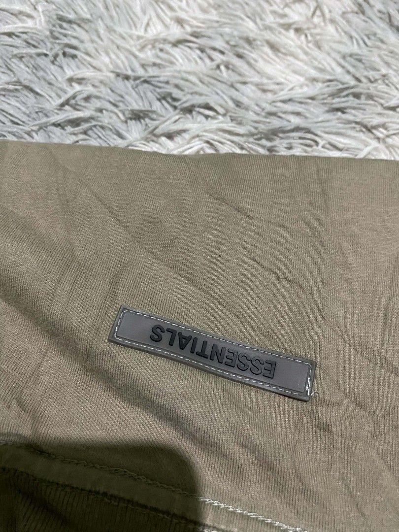 Essentials T-shirt - Olive Green - Size L (Category: Tshirts & Polo Shirts ) located in General Santos City (Dadiangas). Submitted by winter09503 (Listing ID 1415000174, Image 2). Description: Olive green Essentials T-shirt with the brand name printed on the front. Features a size L label. Made of 100% cotton. The shirt has a small Essentials label on the back. Made in China..