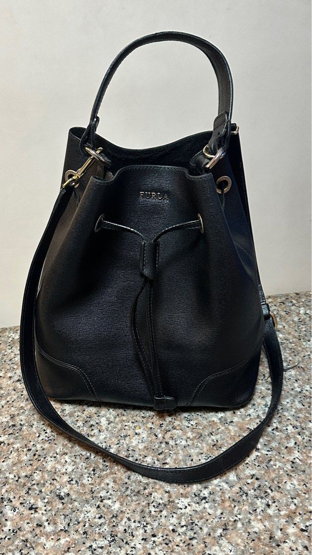 Authentic Furla Black Bucket Bag (Medium) (Category: Luxury Bags & Wallets) located in Manila. Submitted by pamsayat (Listing ID 1414992588, Image 3). Description: Measurements: 10 height x 9 length x 5 width (inches) Condition: • Leather and handle are intact Issues: • Signs of use inside • Faded front hole hardware Reminders: • Last price is already posted and non-negotiable. • This is a preloved bag. Please expect some imperfections due to pri