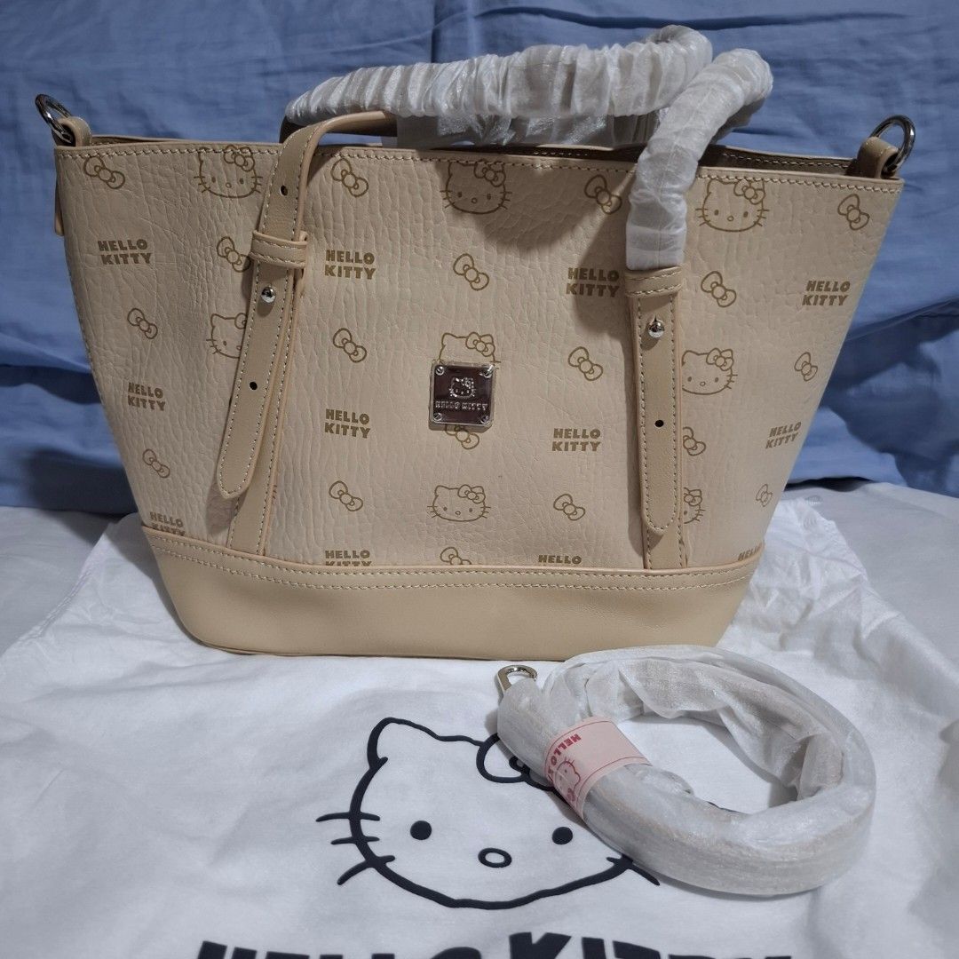 Hello Kitty Handbag with Shoulder Strap (Category: Shoulder Bags) located in Manila. Submitted by mdc08 (Listing ID 1414883565, Image 1). Description: - Original Hello Kitty handbag - Matching detachable shoulder strap (L 117cm) - Open main compartment with detachable pouch - Pouch Interior: zippered pocket and small pocket with brand label - Top handle - Silver-toned metal logo - Dust bag included Dimensions: (approx.) L [T] 32cm / [B] 24cm x H 