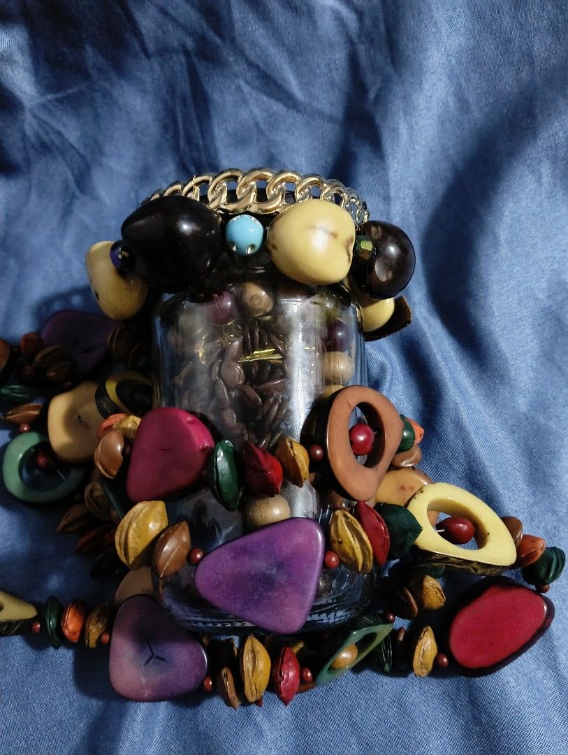 Mystery Jewelry Jar (Category: Accessory Holder, Box & Organizers) located in Iloilo. Submitted by katryce (Listing ID 1414950703, Image 2). Description: Collection of various jewelry pieces stored in a glass jar. Includes bracelets, necklaces, and beads in different colors and styles. Some pieces appear to be made of wood, pearls, and metal. The jar has a black lid and is displayed on a blue fabric background. .