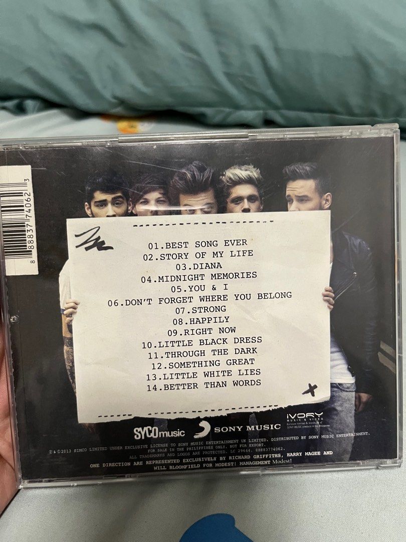 One Direction Midnight Memories CD (Category: CDs & DVDs) located in Angeles City. Submitted by pheeebees (Listing ID 1414945122, Image 2). Description: - Original One Direction "Midnight Memories" CD - Includes CD case and disc - Features popular tracks: "Best Song Ever", "Story of My Life", "Diana", and more - Tracklist visible on the back of the case - Disc features the One Direction logo and album title.