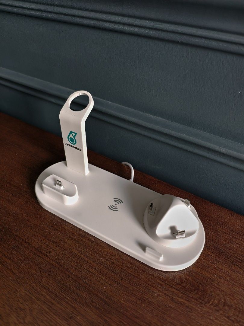 Petronas Multi-Function Charging Stand (Category: Other Gadgets) located in Petaling Jaya. Submitted by junkforfunk (Listing ID 1414844568, Image 2). Description: Petronas Multi-function charging stand is designed for iPhone, AirPods, and Apple Watch. It features a 4-in-1 rotatable charger dock with a USB phone/Type-C phone port. The stand has a wireless charging pad and a sleek white design with the Petronas logo. It comes with its original pack