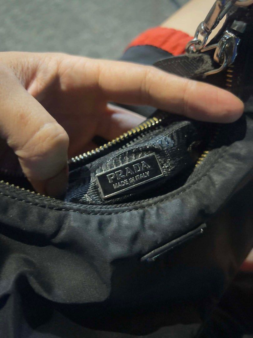 Prada Re-Edition 2000 Mini Bag (Category: Luxury Bags & Wallets) located in Bacolod City. Submitted by novymaesel14868 (Listing ID 1414974444, Image 3). Description: - Prada Re-Edition 2000 mini bag - Color: Black - Features a chain strap - Iconic Prada triangle logo - Made in Italy - Zipper closure - Interior tag number: 165 - A classic and stylish accessory.