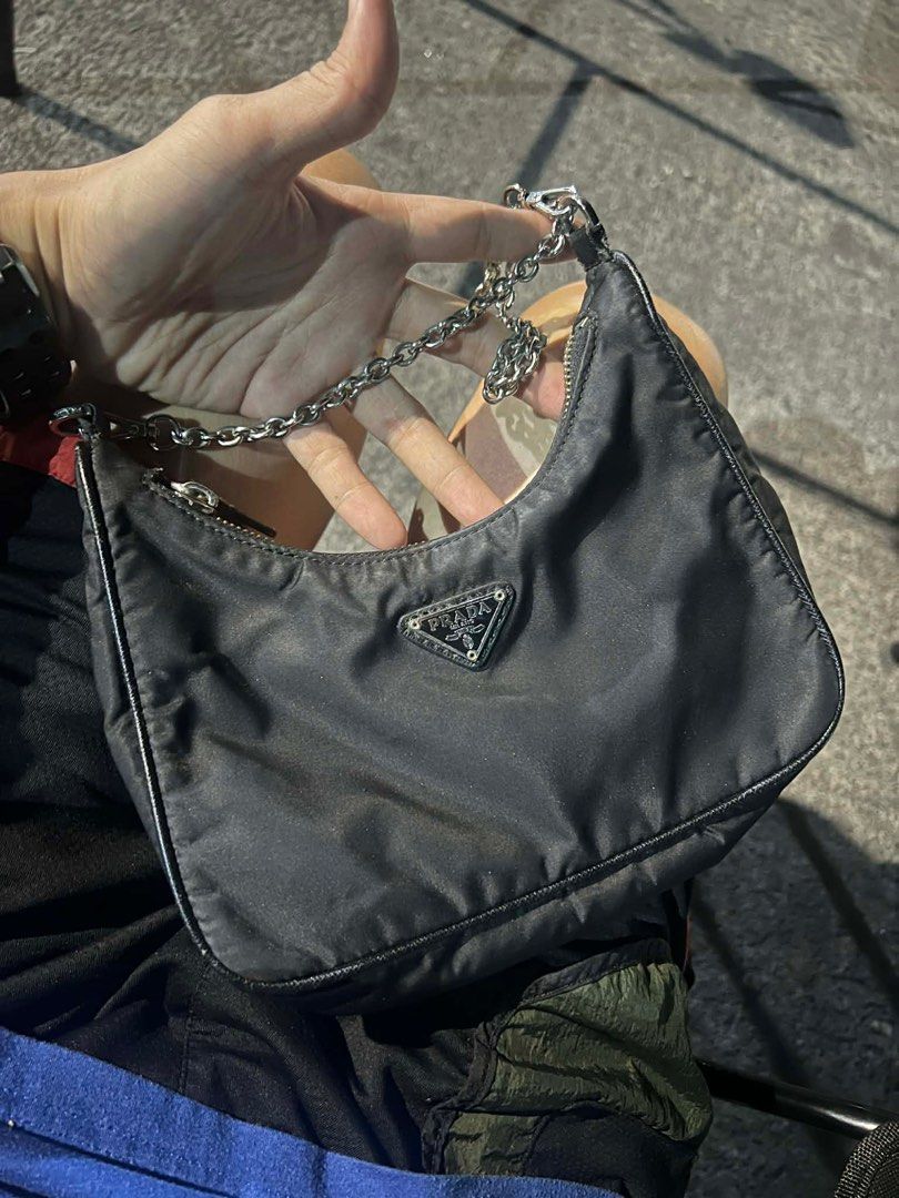Prada Re-Edition 2000 Mini Bag (Category: Luxury Bags & Wallets) located in Bacolod City. Submitted by novymaesel14868 (Listing ID 1414974444, Image 1). Description: - Prada Re-Edition 2000 mini bag - Color: Black - Features a chain strap - Iconic Prada triangle logo - Made in Italy - Zipper closure - Interior tag number: 165 - A classic and stylish accessory.