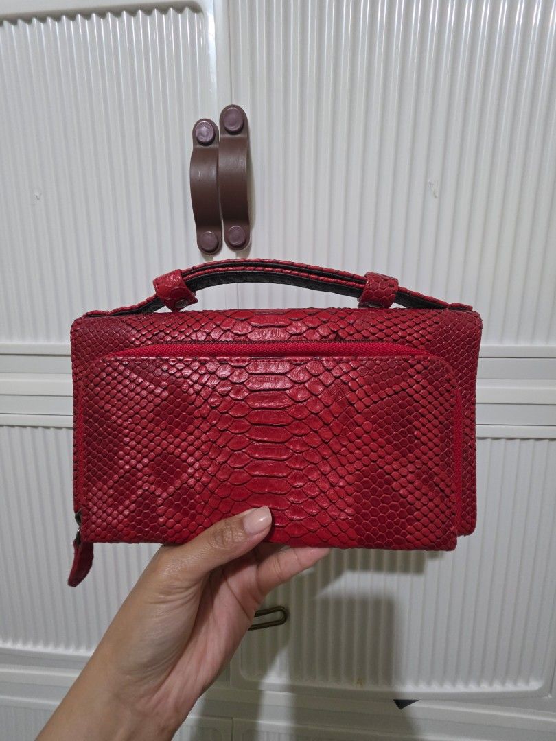 Red Snake Skin Clutch Bag (Category: Wallets & Card holders) located in Las Pinas. Submitted by andthelike (Listing ID 1415005790, Image 2). Description: - Red wallet with snake skin texture - Flap closure with snap button - Multiple compartments - Includes a zippered pocket - Black interior lining - Sleek, rectangular design - No sling included.