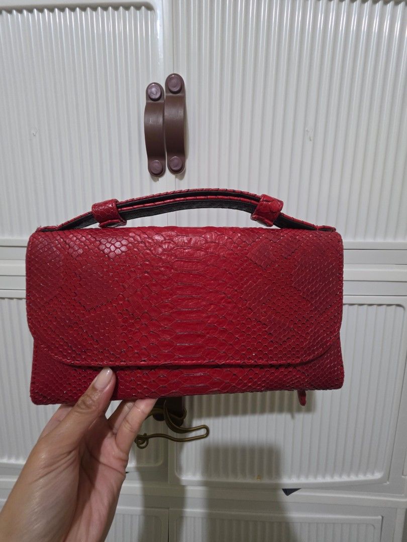 Red Snake Skin Clutch Bag (Category: Wallets & Card holders) located in Las Pinas. Submitted by andthelike (Listing ID 1415005790, Image 1). Description: - Red wallet with snake skin texture - Flap closure with snap button - Multiple compartments - Includes a zippered pocket - Black interior lining - Sleek, rectangular design - No sling included.