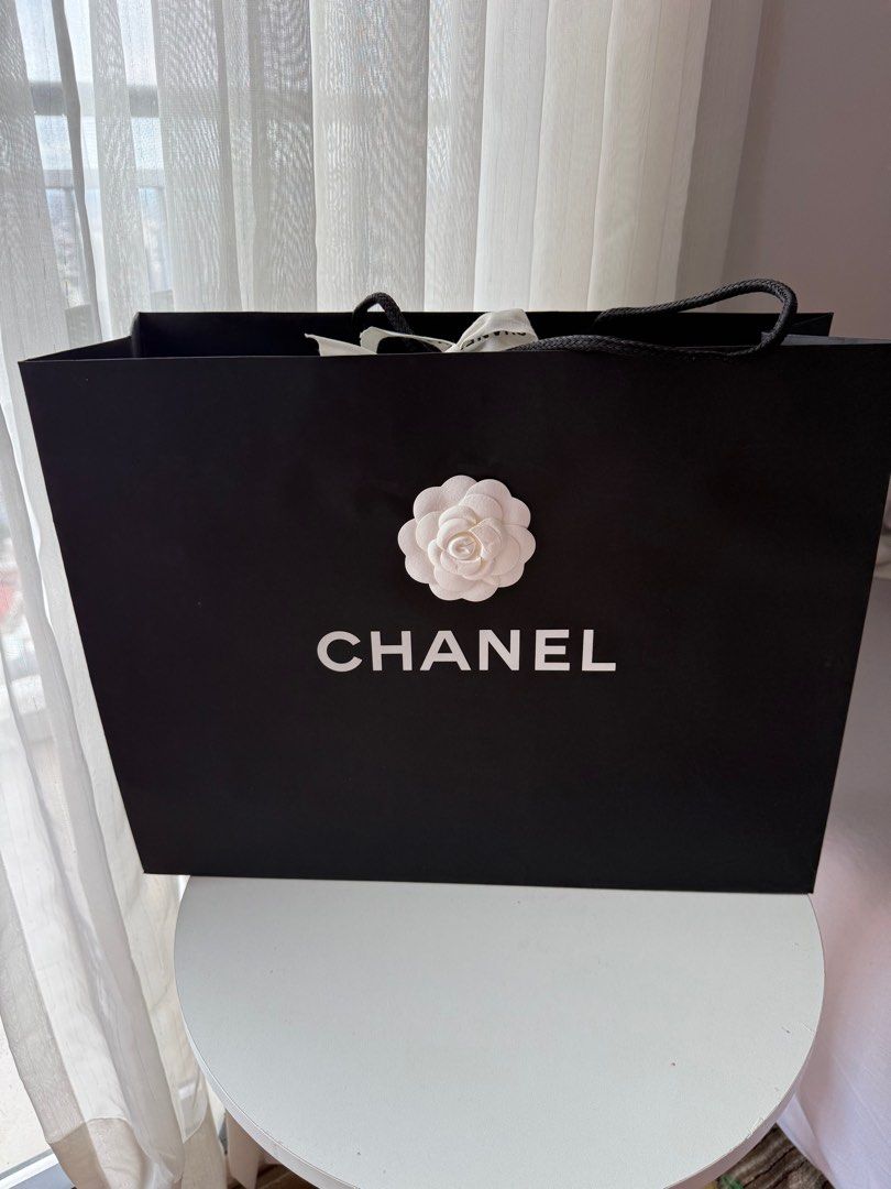 Chanel Shopping Bag (Category: Luxury Bags & Wallets) located in Makati City. Submitted by vintage_beauty1 (Listing ID 1415103498, Image 1). Description: - Authentic Chanel shopping bag - Black exterior with white Chanel logo - Includes a white camellia flower - Comes with a Chanel ribbon - Dimensions: H = 33.5CM L = 43CM W = 16CM Location: Makati Pick up or buyer can arrange lalamove or grab express pick up. Price: 1,450 Final sale .