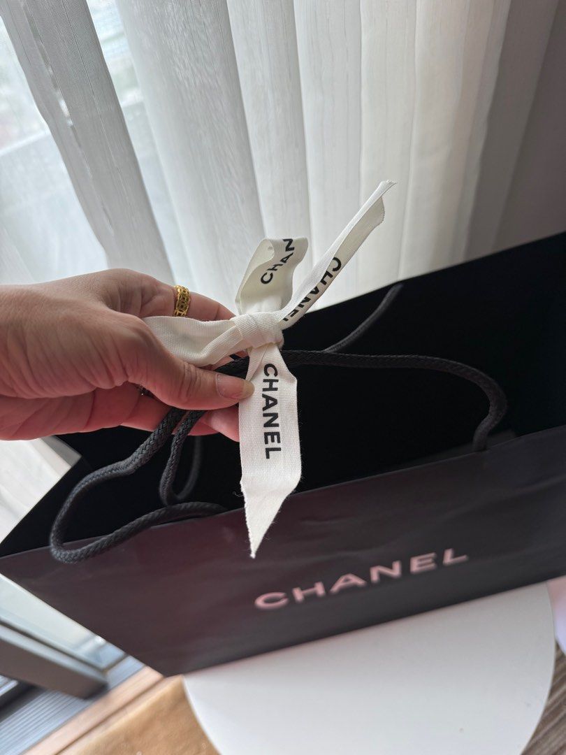 Chanel Shopping Bag (Category: Luxury Bags & Wallets) located in Makati City. Submitted by vintage_beauty1 (Listing ID 1415103498, Image 3). Description: - Authentic Chanel shopping bag - Black exterior with white Chanel logo - Includes a white camellia flower - Comes with a Chanel ribbon - Dimensions: H = 33.5CM L = 43CM W = 16CM Location: Makati Pick up or buyer can arrange lalamove or grab express pick up. Price: 1,450 Final sale .