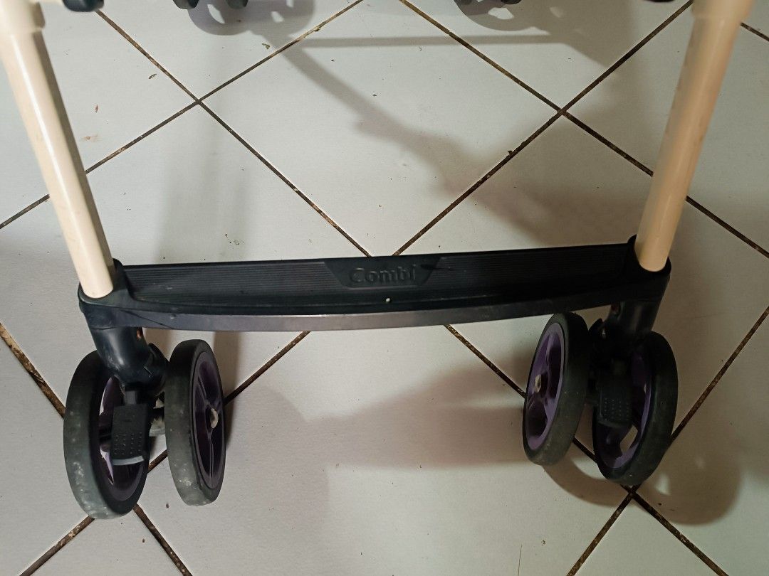 Combi Stroller (Category: Strollers) located in Manila. Submitted by ofwmom (Listing ID 1415056727, Image 3). Description: - Combi stroller with a stylish navy blue and pink design. - Includes a sunshade for added protection. - Equipped with a safety harness for your child's security. - Features a comfortable brown handle. - Sturdy beige frame with durable black wheels. - Authentic Combi logo on the handle and footrest..
