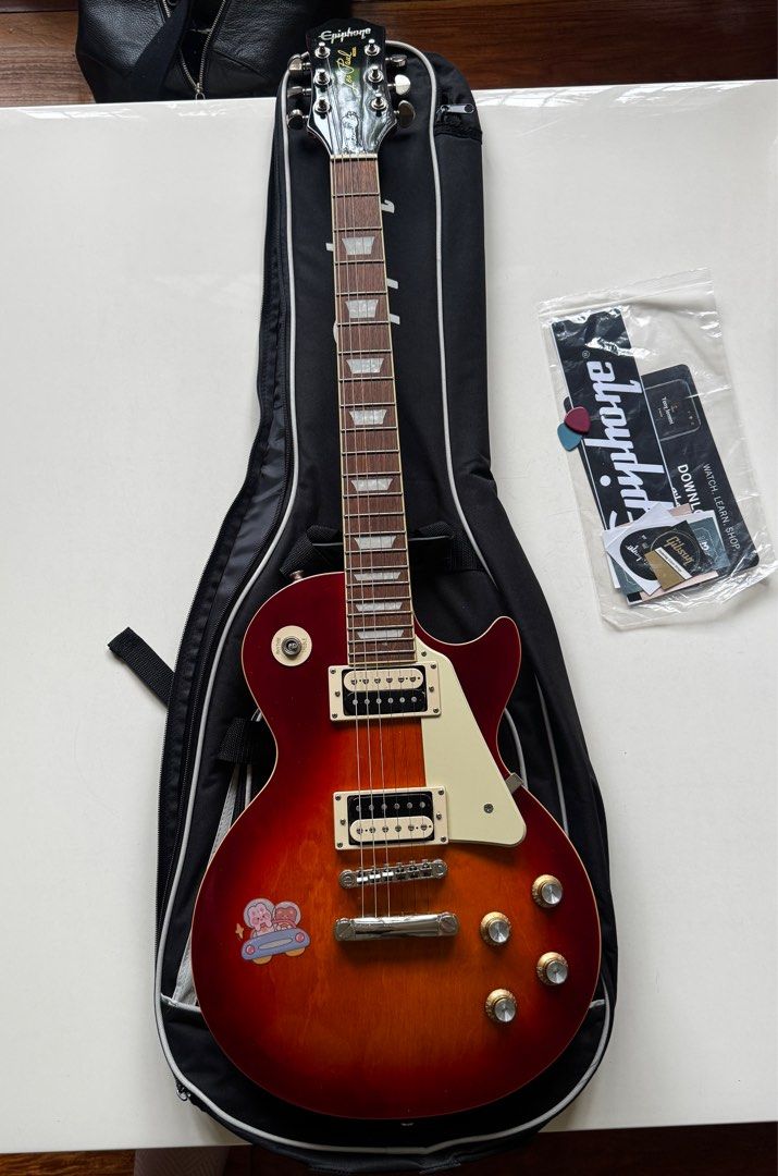 Epiphone Les Paul Electric Guitar (Category: Musical Instruments) located in Quezon City. Submitted by tulip03 (Listing ID 1415167200, Image 1). Description: - Epiphone Les Paul electric guitar - Sunburst finish - Includes gig bag and accessories - Rosewood fretboard - Classic Les Paul body shape - Epiphone headstock logo - Well-maintained condition.