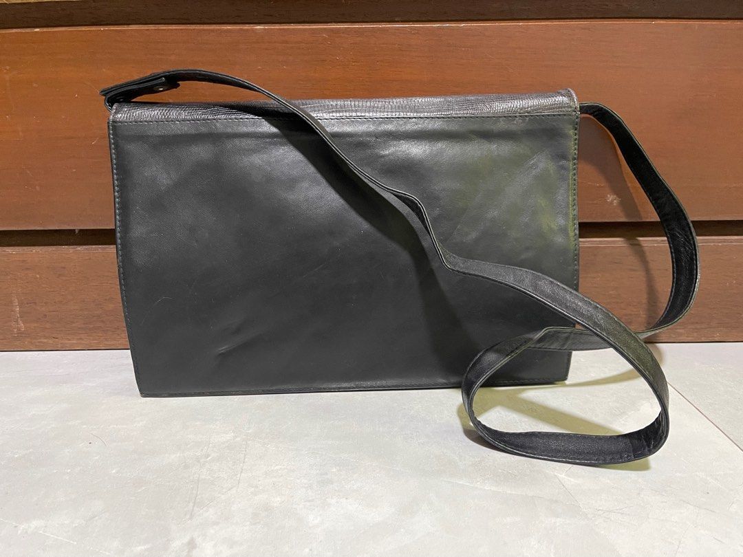 Gianni Versace Leather Crossbody Bag (Category: Luxury Bags & Wallets) located in Bacnotan. Submitted by anosellmo (Listing ID 1415041713, Image 3). Description: - Gianni Versace crossbody bag - Black leather - Silver-tone hardware - Textured flap with chain detail - Adjustable long strap - Multiple interior compartments - Zippered pocket - Signature patterned lining.