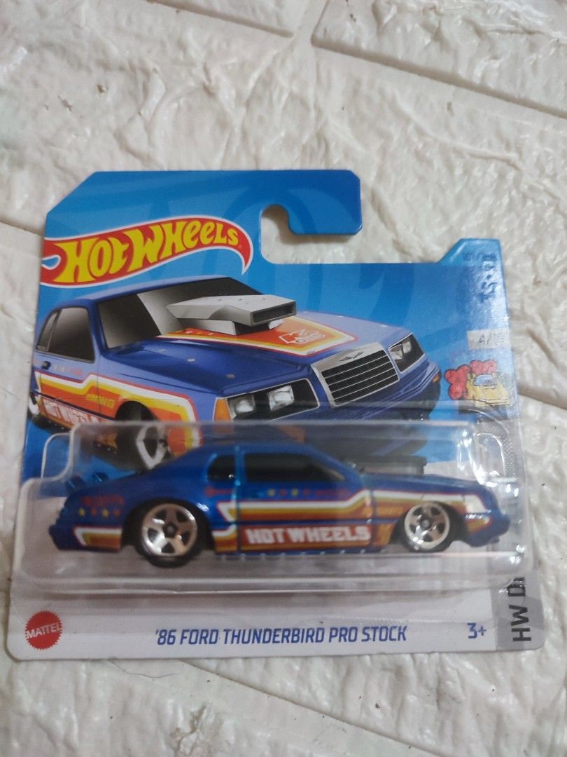 Hot Wheels '86 Ford Thunderbird Pro Stock (Category: Vehicle & Diecast Models) located in Narvacan. Submitted by jigger85 (Listing ID 1415174690, Image 1). Description: - Hot Wheels '86 Ford Thunderbird Pro Stock. - Blue body with vibrant graphics. - Features the Hot Wheels logo. - Part of the 2023 Mini Drag Strip series. - Age recommendation: 3+. - Brand new in original packaging..