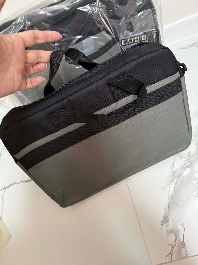 HP Laptop Bag with Shoulder Strap Gray Black (Category: Laptop Bags & Sleeves) located in Caloocan City. Submitted by mary_rose_04 (Listing ID 1415159279, Image 3). Description: HP laptop bag with a shoulder strap and a handle. It has a black top and a gray bottom with the HP logo. The bag has a zipper closure and an interior compartment..