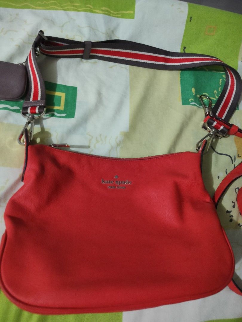 Kate Spade Red Shoulder Bag (Category: Luxury Bags & Wallets) located in Manila. Submitted by allaboutzara (Listing ID 1415162586, Image 2). Description: - Kate Spade shoulder bag - Vibrant red orange color - Includes: - Striped shoulder strap - Red crossbody strap - Matching coin purse - Zippered closure - Kate Spade logo on front.