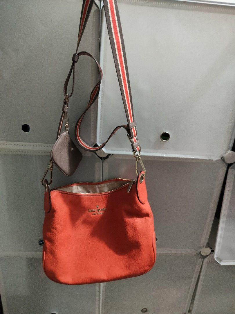Kate Spade Red Shoulder Bag (Category: Luxury Bags & Wallets) located in Manila. Submitted by allaboutzara (Listing ID 1415162586, Image 3). Description: - Kate Spade shoulder bag - Vibrant red orange color - Includes: - Striped shoulder strap - Red crossbody strap - Matching coin purse - Zippered closure - Kate Spade logo on front.