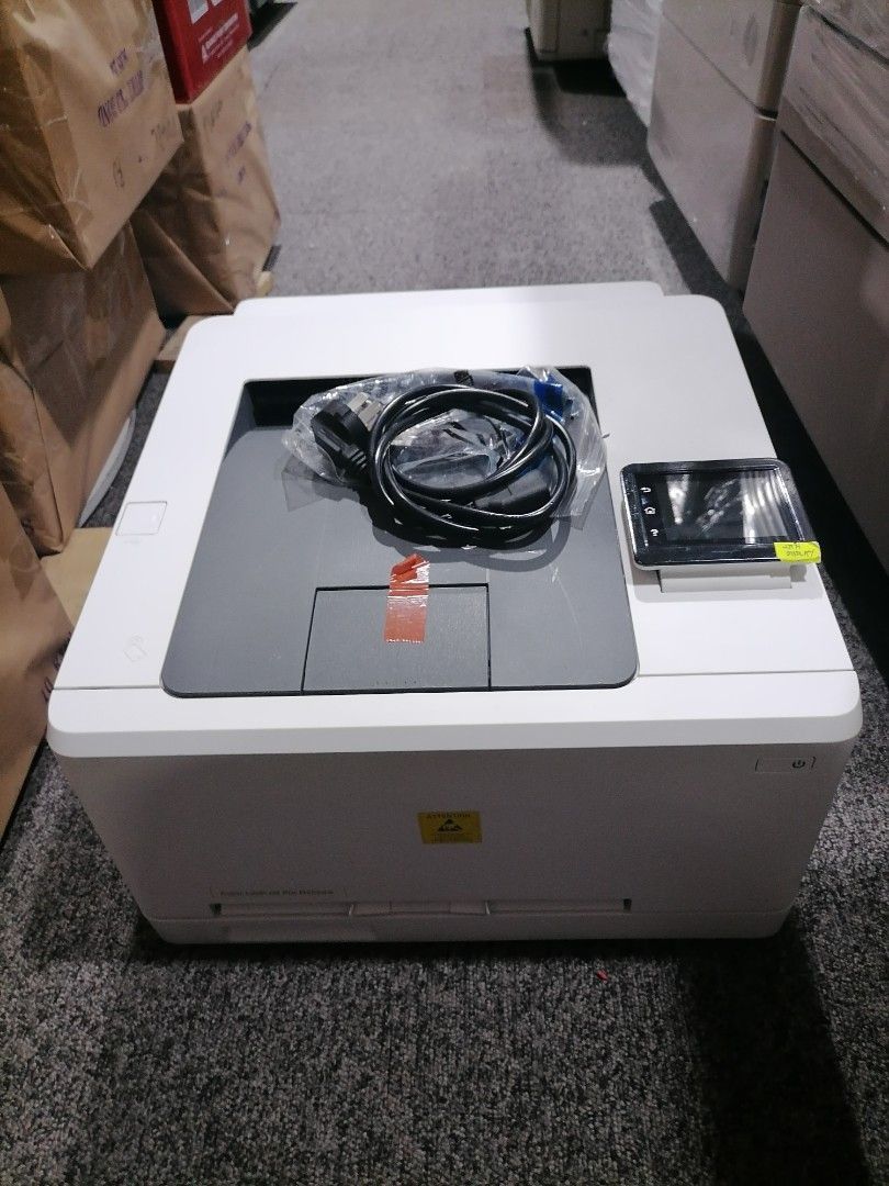 Laser Printer with Cables (Category: Printers, Scanners & Copiers) located in Quezon City. Submitted by copieronlineinc (Listing ID 1415095833, Image 1). Description: White laser printer with a control panel. Includes a power cable and other cables. The printer has a gray top cover. Ready for use..