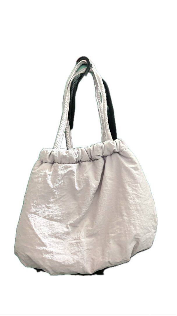Medium sized puffy bag (Category: Tote Bags) located in Taguig. Submitted by httpgrant (Listing ID 1415225142, Image 3). Description: - Puffy, padded design - Drawstring closure - Two shoulder straps - Available colors: Black and Light purple - Smooth, possibly nylon-like material - Great size for everyday use.