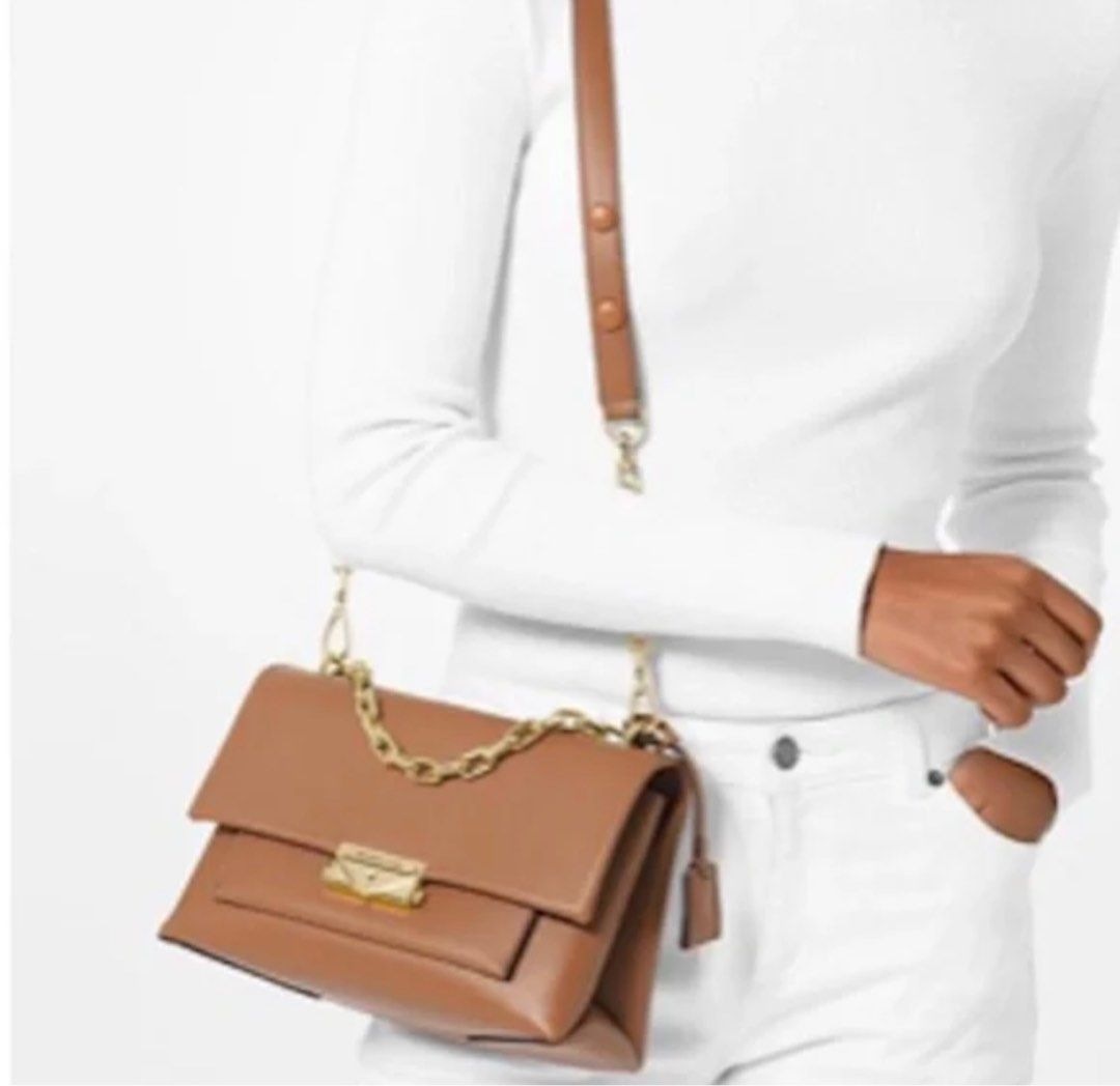 Michael Kors Cece medium (Category: Luxury Bags & Wallets) located in Cebu City. Submitted by forless.ph (Listing ID 1415200717, Image 3). Description: Authenic 💯Michael Kors shoulder cece bag features a tan leather exterior with a gold-tone chain strap and hardware. It has a flap closure with a lock detail and a small tag. The bag can be worn over the shoulder or crossbody. Good as brandnew condition. With dustbag and care care card. Selling lo