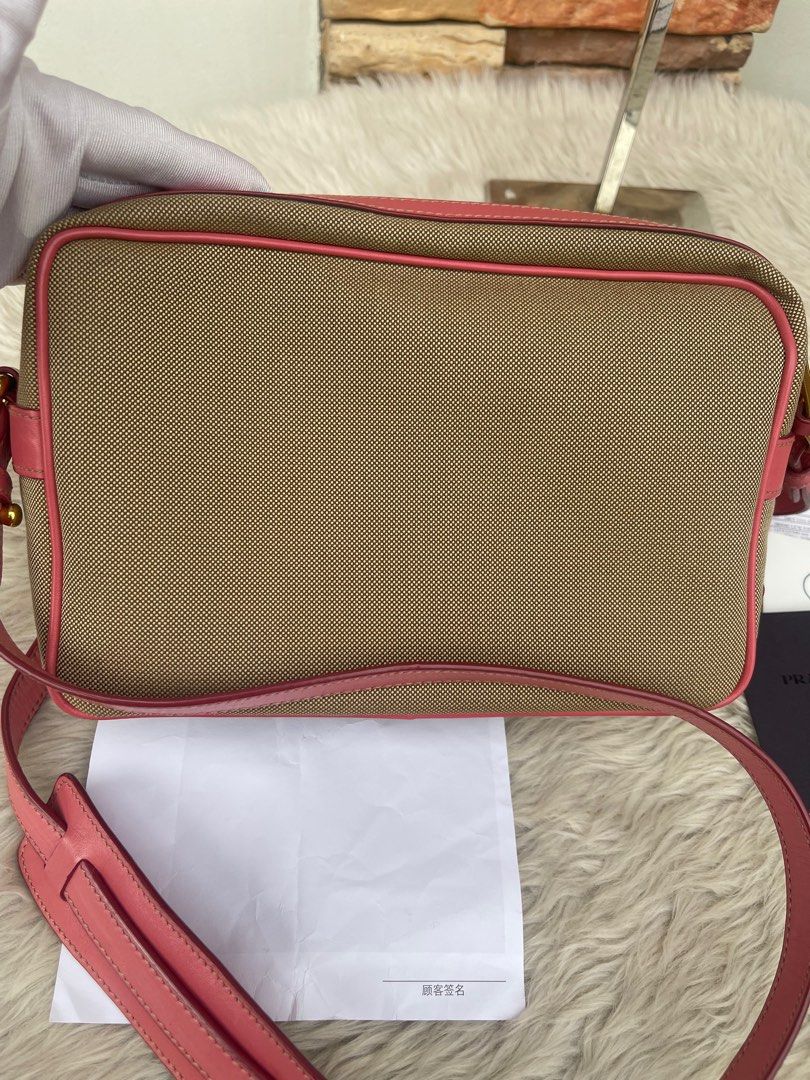 Prada Crossbody Bag with Bow Detail (Category: Luxury Bags & Wallets) located in Cavite. Submitted by authenticfindsbyging (Listing ID 1415044749, Image 3). Description: - Authentic Prada crossbody bag - Canvas body with pink leather trim - Features a bow detail - Gold-tone zipper and hardware - Prada-branded fabric lining - Includes detachable strap - Comes with authenticity cards and receipt.