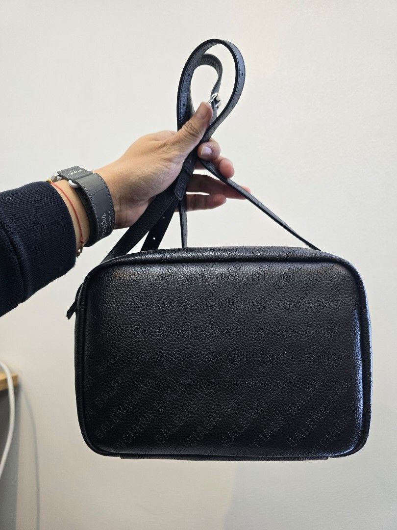Balenciaga Everyday Black Perforated Camera bag (Category: Luxury Bags & Wallets) located in Taguig. Submitted by mluxeph (Listing ID 1415258328, Image 1). Description: Balenciaga Everyday Black Perforated Camera bag Gender: Ladies’ Material: Calfskin leather Stamp: 679267 1000 Q 528147 Interior: One open pocket and one main compartment Measurements: 9”L X 2.6”W X 6.25”H Handle Drop: 20" adjustable Hardware: Silver tone Inclusions: Original dust 