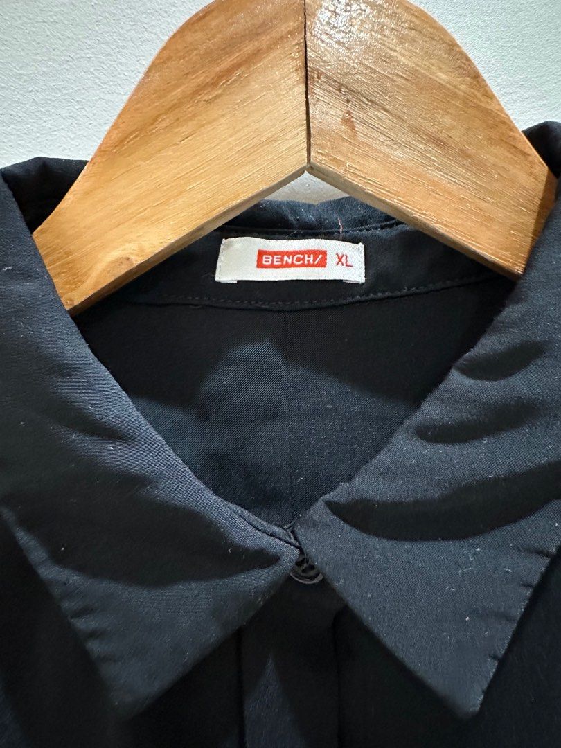 Bench Black Short Sleeve Shirt XL (Category: Shirts) located in Quezon City. Submitted by alloriginalthrift (Listing ID 1415355015, Image 3). Description: Black short sleeve shirt from Bench. It has a collared neckline and button-down front. Still in very good condition. Made of a smooth, likely synthetic fabric..