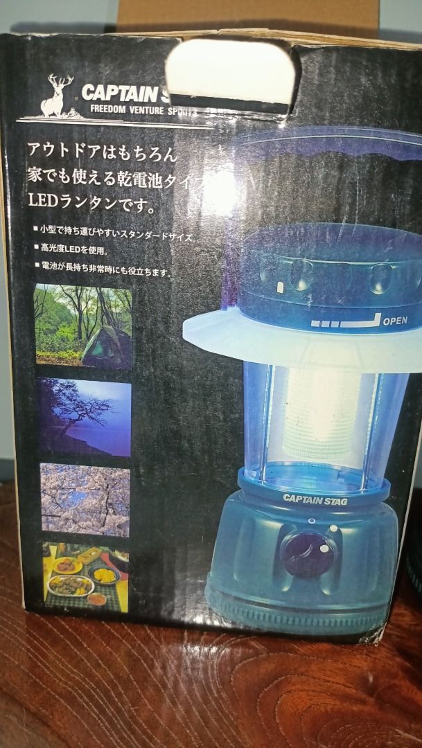 Captain Stag LED Lantern for Camping (Category: Lighting) located in Munoz. Submitted by larryc1212 (Listing ID 1415321461, Image 3). Description: Captain Stag LED lantern. The lantern is dark green with a clear lamp cover. It has an adjustable knob and a handle. The box shows the lantern's features and some example usage scenarios. The lantern is approximately 8 inches tall. This is battery operated. Item may or may not include some scratches du
