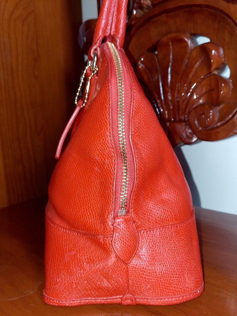 Coach Orange Red Leather Dome Satchel Handbag (Category: Purses & Pouches) located in Quezon, Nueva Vizcaya. Submitted by closet_infinity (Listing ID 1415291448, Image 3). Description: Coach handbag features a vibrant orange red leather exterior with a dome shape. It has dual top handles and a zip-top closure. The interior is also orange red and includes a Coach leather tag. The bag has a gold-tone zipper and hardware. A Coach hangtag is attached