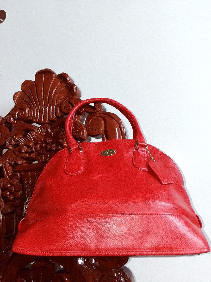 Coach Orange Red Leather Dome Satchel Handbag (Category: Purses & Pouches) located in Quezon, Nueva Vizcaya. Submitted by closet_infinity (Listing ID 1415291448, Image 1). Description: Coach handbag features a vibrant orange red leather exterior with a dome shape. It has dual top handles and a zip-top closure. The interior is also orange red and includes a Coach leather tag. The bag has a gold-tone zipper and hardware. A Coach hangtag is attached