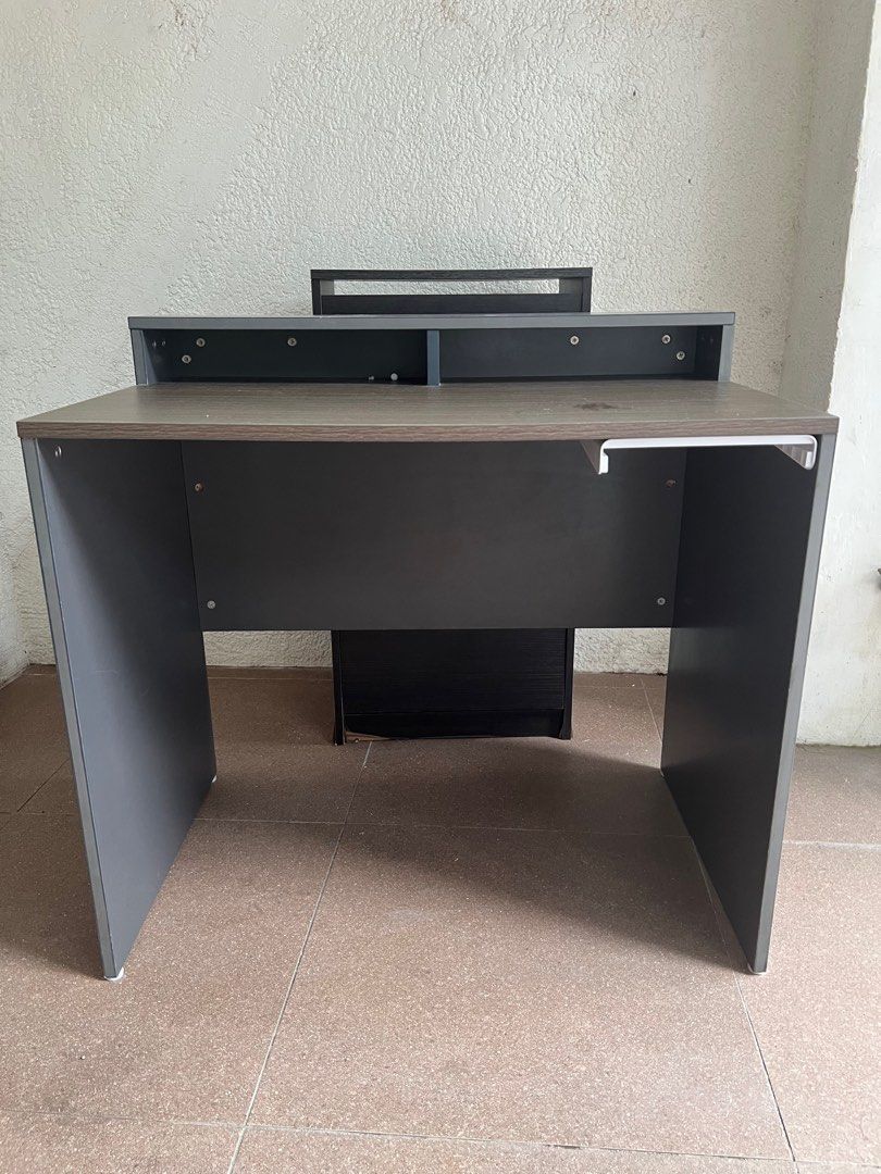 Study table / computer table (Category: Desktops) located in Manila. Submitted by raymiii (Listing ID 1415359756, Image 2). Description: grey and dark wood-finish particle board office or computer desk with an elevated monitor stand and a small under-desk storage unit. Still nego.