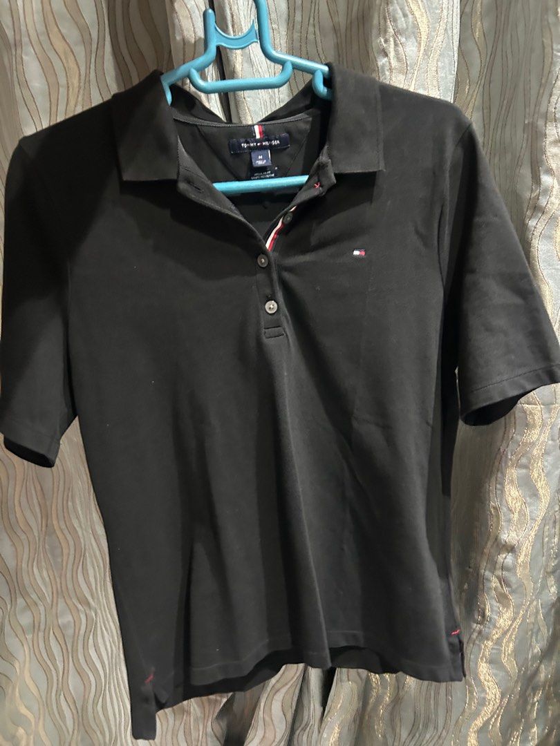 Tommy Hilfiger Black Polo Shirt - Medium (Category: Shirts) located in Manila. Submitted by lrocamora (Listing ID 1415401656, Image 2). Description: - Tommy Hilfiger black polo shirt - Size: Medium - Features the iconic Tommy Hilfiger logo - Regular fit - Classic design - Short sleeves - Three-button placket - Collar with Tommy Hilfiger stripe detail.