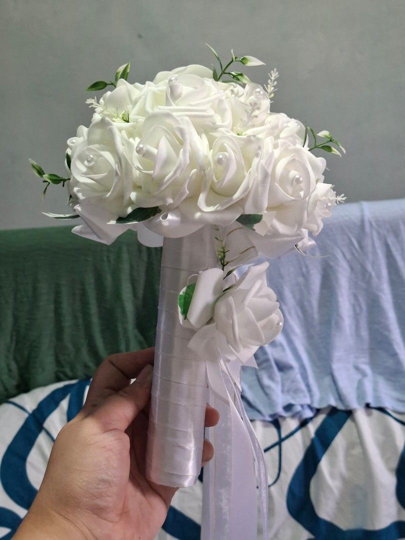 White Rose Wedding Bouquet (Category: Flowers & Bouquets) located in Valenzuela. Submitted by grace_dinong (Listing ID 1415369745, Image 3). Description: - Stunning white rose bouquet - Ideal for weddings and special occasions - Features multiple white roses - Includes pearl accents and delicate greenery - Comes with a ribbon-wrapped handle.