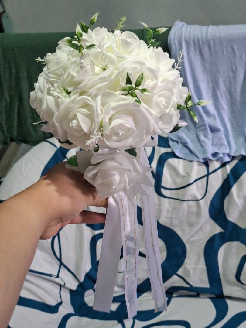 White Rose Wedding Bouquet (Category: Flowers & Bouquets) located in Valenzuela. Submitted by grace_dinong (Listing ID 1415369745, Image 1). Description: - Stunning white rose bouquet - Ideal for weddings and special occasions - Features multiple white roses - Includes pearl accents and delicate greenery - Comes with a ribbon-wrapped handle.