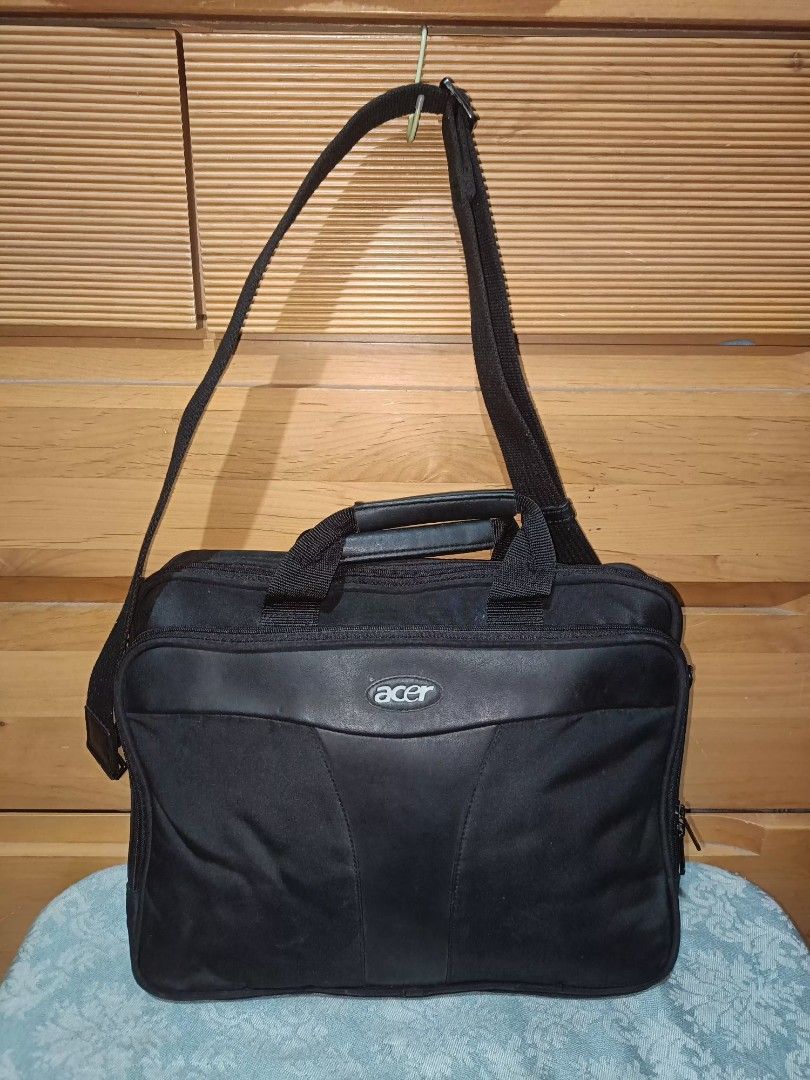 Acer Laptop Bag with Shoulder Strap (Category: Laptop Bags & Sleeves) located in Baguio. Submitted by iyaberong48242 (Listing ID 1415469536, Image 1). Description: Black Acer laptop bag with a shoulder strap and a handle. It has a front pocket with the Acer logo. The bag has a main compartment and a side pocket. The bag measures approximately 14 inches in height and 13 inches in width. The depth is about 2 inches. The interior is black with Acer 