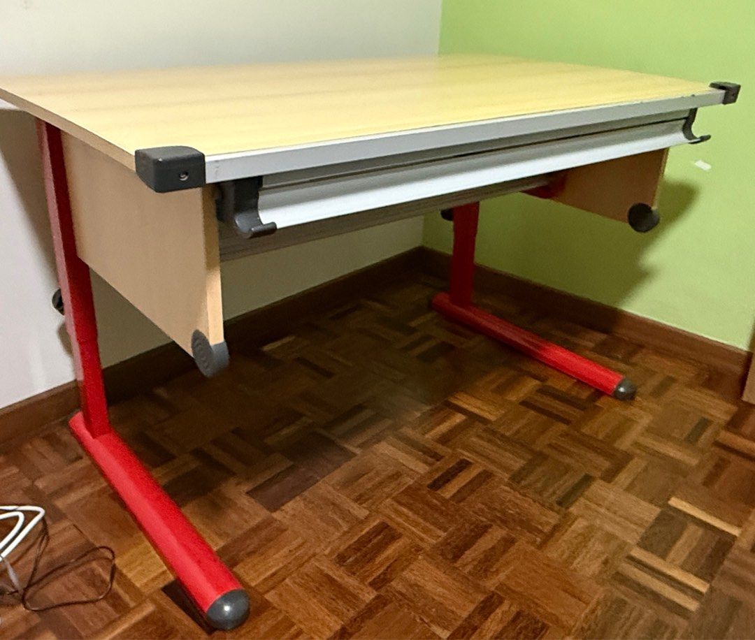 Adjustable Drafting Table - Red Frame (Category: Tables & Sets) located in Singapore. Submitted by cupcakeangel01 (Listing ID 1415548952, Image 1). Description: Good conditions Study /working table. 120 x 70 cm wood laminated table top, adjustable, tilting at your desired working angle up to 45deg. Adjustable height legs, min 70cm ht. Designed with a storage tray under the table. suitable for Art craft drawing / engineering drafting or used as co