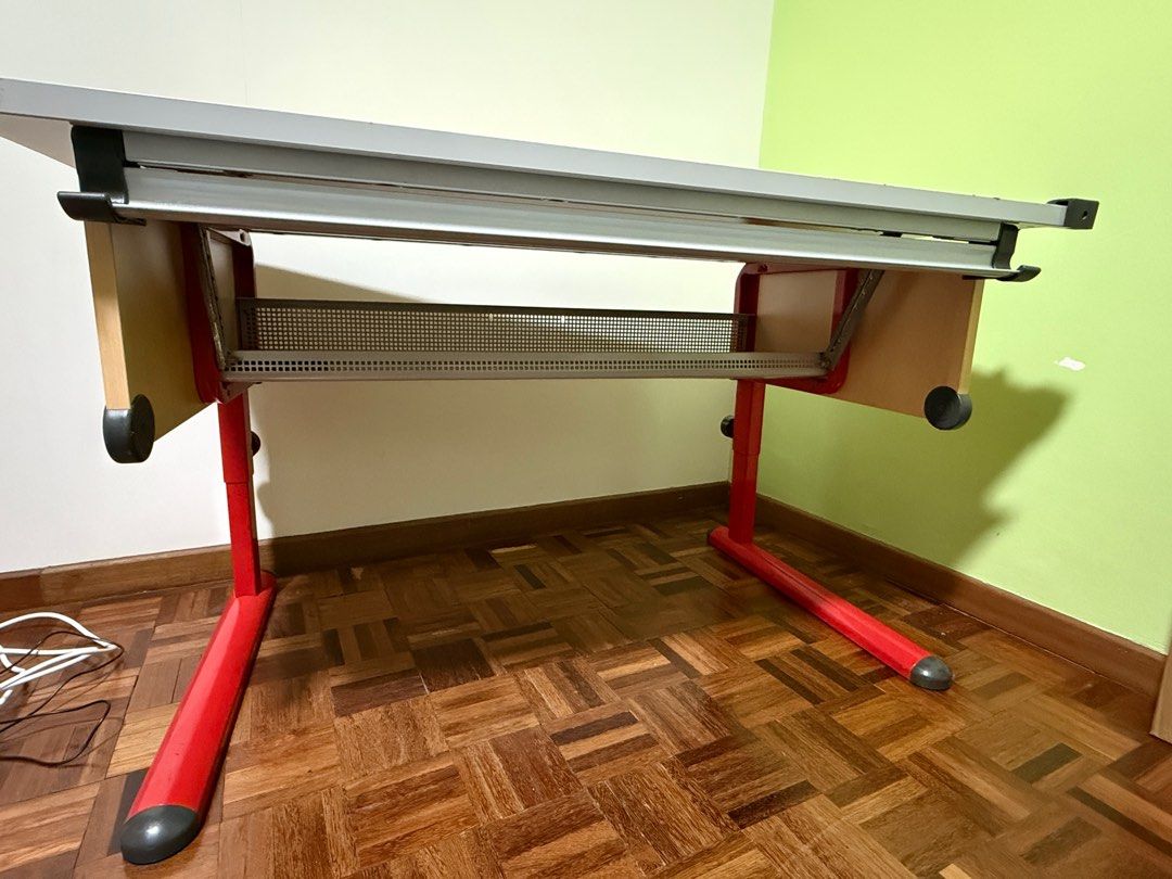 Adjustable Drafting Table - Red Frame (Category: Tables & Sets) located in Singapore. Submitted by cupcakeangel01 (Listing ID 1415548952, Image 3). Description: Good conditions Study /working table. 120 x 70 cm wood laminated table top, adjustable, tilting at your desired working angle up to 45deg. Adjustable height legs, min 70cm ht. Designed with a storage tray under the table. suitable for Art craft drawing / engineering drafting or used as co