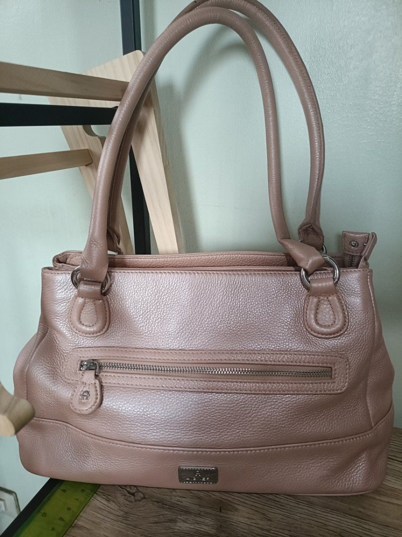 Aigner Leather Handbag (Category: Luxury Bags & Wallets) located in Quezon City. Submitted by pinksgate31 (Listing ID 1415624099, Image 1). Description: - Authentic Aigner handbag - Neutral color, classic design - Two top handles - Front zipper pocket - Multiple interior compartments - Metal Aigner logo - Protective metal feet - Made of leather.