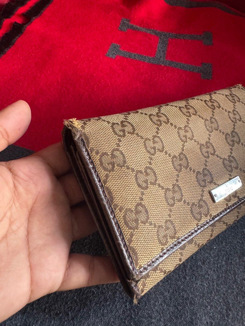 Authentic Gucci GG Canvas Wallet (Category: Luxury Bags & Wallets) located in Pasig City. Submitted by pau01_ (Listing ID 1415495997, Image 2). Description: Authentic Gucci GG canvas wallet. Brown leather interior with card slots, compartments, and a coin pocket. Shows wear on edges. Made in Italy..