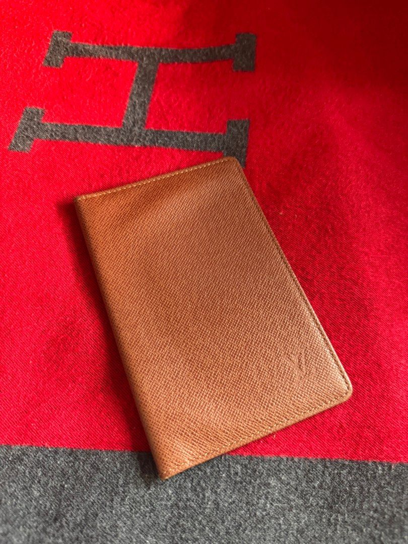 Authentic Louis Vuitton Card Holder (Category: Luxury Bags & Wallets) located in Pasig City. Submitted by pau01_ (Listing ID 1415497374, Image 1). Description: - Authentic Louis Vuitton passport holder - Color: Brown - Features a textured exterior - Iconic LV logo visible - Rectangular shape - Crafted from leather.