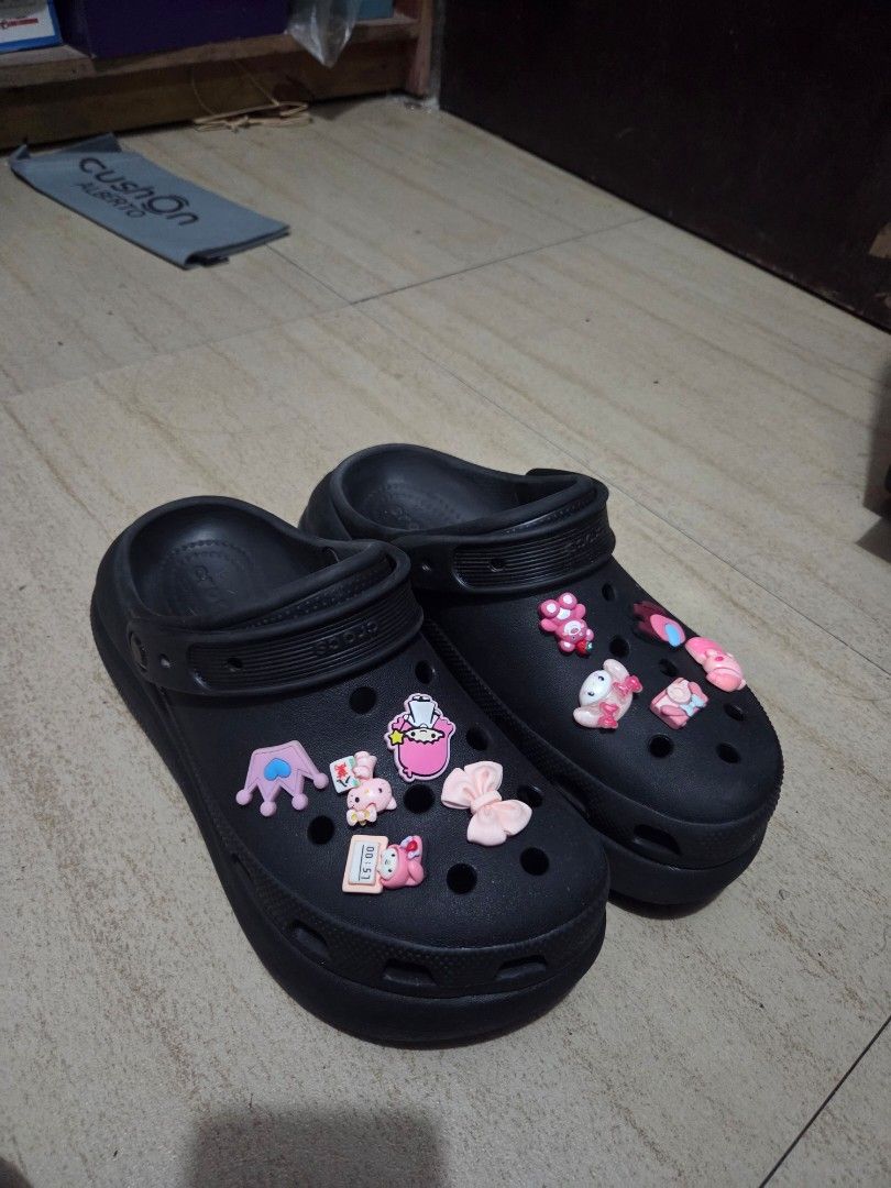 Black Crocs Platform Clogs with Jibbitz (Category: Slippers and slides) located in San Pedro. Submitted by zllerrzz (Listing ID 1415559192, Image 1). Description: - Black clogs with cute jibbitz charms. - Includes Kitty, bows, and other designs. - Features a thick sole and back strap. - Soles show some wear. - Size m6 w8 25cm .