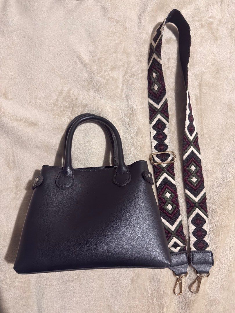 Parisian Black Handbag with Detachable Strap (Category: Shoulder Bags) located in Manila. Submitted by jazsolian (Listing ID 1415576646, Image 1). Description: - Black handbag - Structured design with top handle - Detachable, patterned shoulder strap - Spacious interior - Simple and elegant design - Suitable for various occasions - Secure closure - Smooth material.