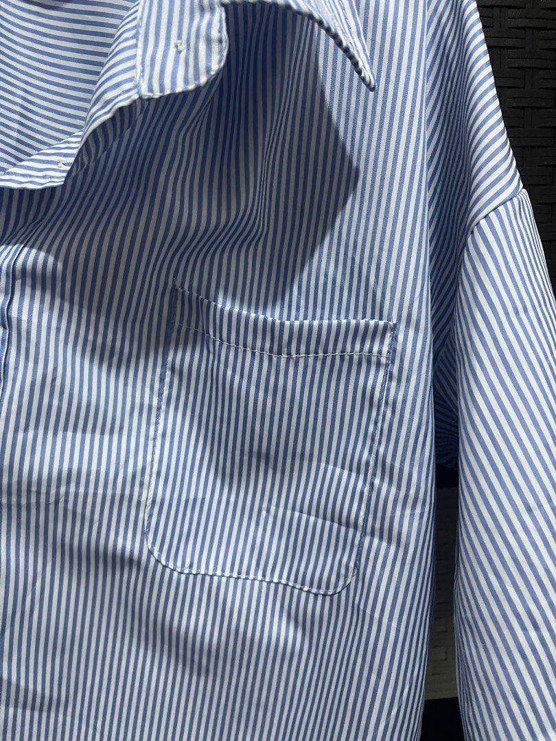 Blue and White Striped Button-Down Shirt (Category: Shirts) located in Paranaque City. Submitted by rieclutter (Listing ID 1415542916, Image 3). Description: - Can fit s-m - Blue and white striped button-down shirt - Collared neckline - Short sleeves - Single chest pocket - Relaxed fit - Button-up closure.