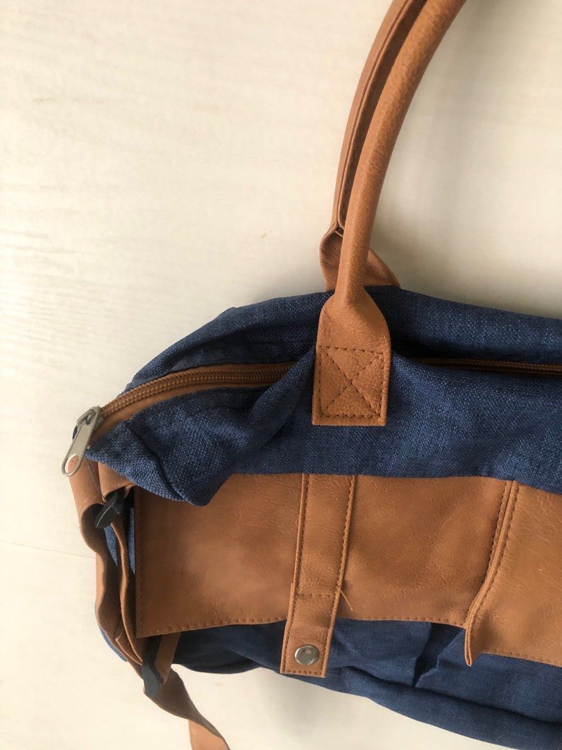 Blue Denim Handbag with Brown Accents (Category: Luxury Bags & Wallets) located in Pasig City. Submitted by maxscollections (Listing ID 1415528600, Image 3). Description: Minimum purchase 500 from my list Length 8” Width 15” Thickness 2” - Blue denim handbag with brown accents - Two top handles - Detachable shoulder strap - Front flap with snap closures - Zippered top closure.