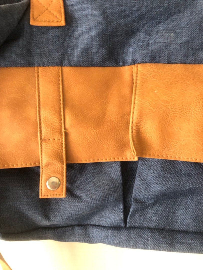 Blue Denim Handbag with Brown Accents (Category: Luxury Bags & Wallets) located in Pasig City. Submitted by maxscollections (Listing ID 1415528600, Image 2). Description: Minimum purchase 500 from my list Length 8” Width 15” Thickness 2” - Blue denim handbag with brown accents - Two top handles - Detachable shoulder strap - Front flap with snap closures - Zippered top closure.