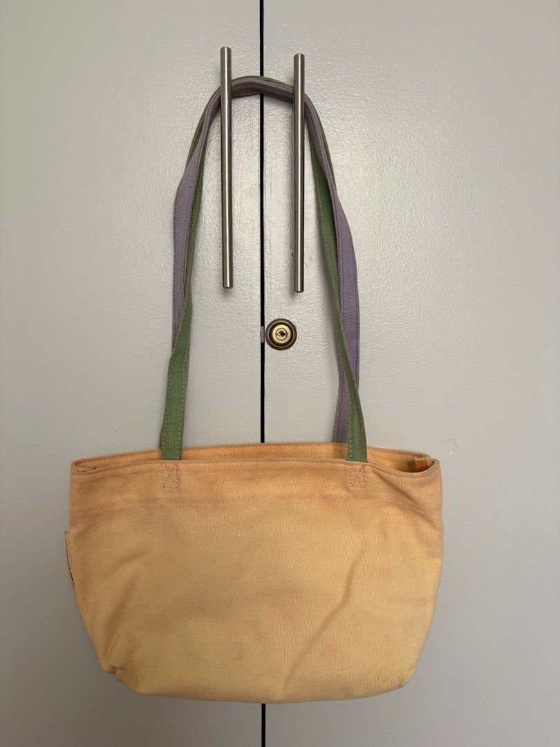 Canvas Tote Bag with Colorful Straps (Category: Tote Bags) located in Valenzuela. Submitted by maesquared (Listing ID 1415528568, Image 1). Description: - Beige canvas tote bag - Contrasting green and purple straps - Spacious interior - Drawstring closure - Durable canvas material - Comfortable shoulder straps - Practical and stylish Note: needs cleaning.