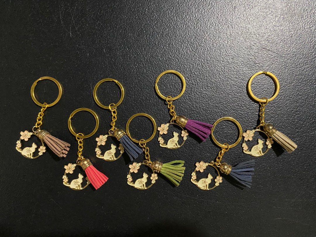 Cat and Flower Keychains with Tassels (Category: Charms) located in Valenzuela. Submitted by emg.everythingmustgo (Listing ID 1415554434, Image 1). Description: 100 each - Cat silhouette design with flower accents - Gold-colored ring, chain, and charm - Tassels available in brown, red, blue, green, and purple - Adds charm to keys or bags - Great gift for cat lovers.