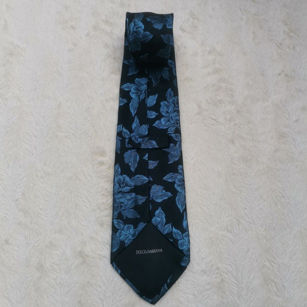 Dolce & Gabbana Floral Tie (Category: Ties) located in Manila. Submitted by titojay (Listing ID 1415456987, Image 2). Description: - Dolce & Gabbana tie - Silk material - Black background with blue floral design - Dolce & Gabbana logo present - Ideal for formal occasions.