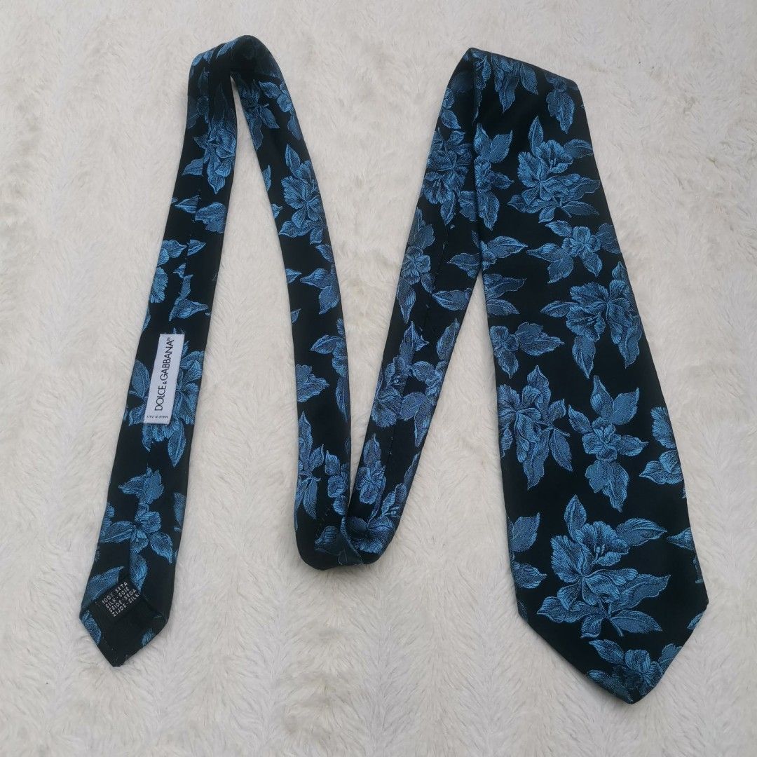 Dolce & Gabbana Floral Tie (Category: Ties) located in Manila. Submitted by titojay (Listing ID 1415456987, Image 3). Description: - Dolce & Gabbana tie - Silk material - Black background with blue floral design - Dolce & Gabbana logo present - Ideal for formal occasions.